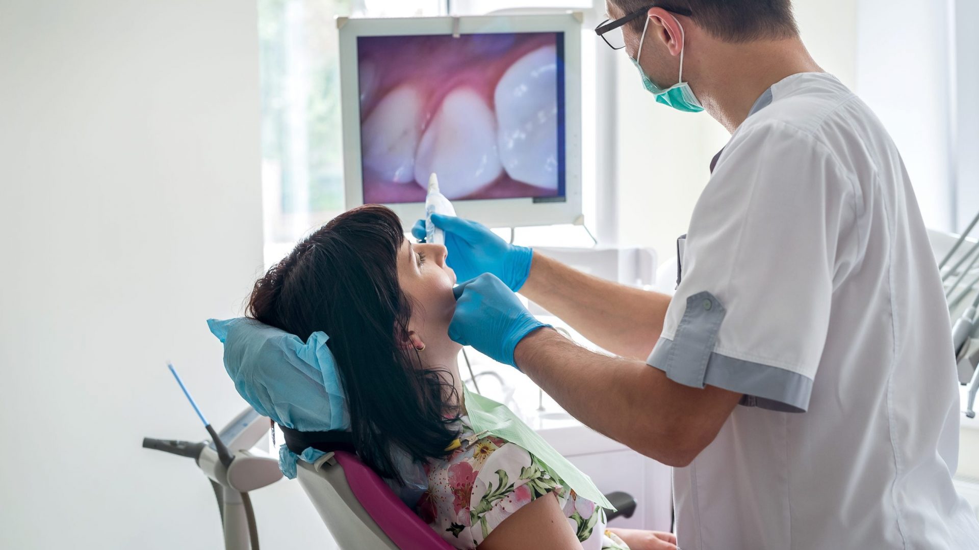 Doctor examining patient's teeth with intraoral camera